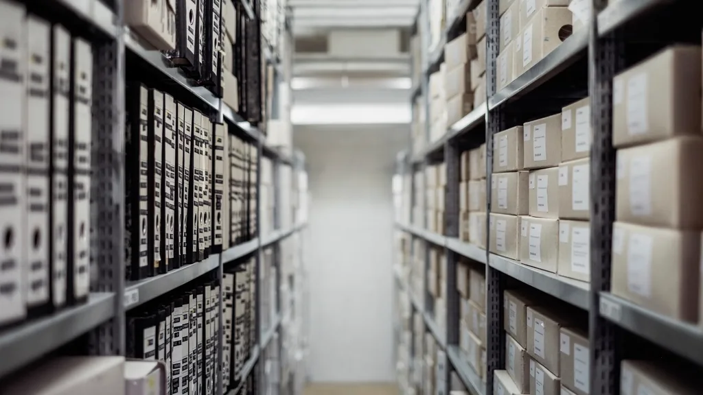 An aisle of archive shelves holding binders and storage boxes