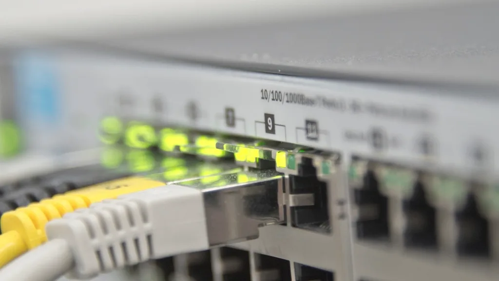Network cables plugged into a switch with green port lights
