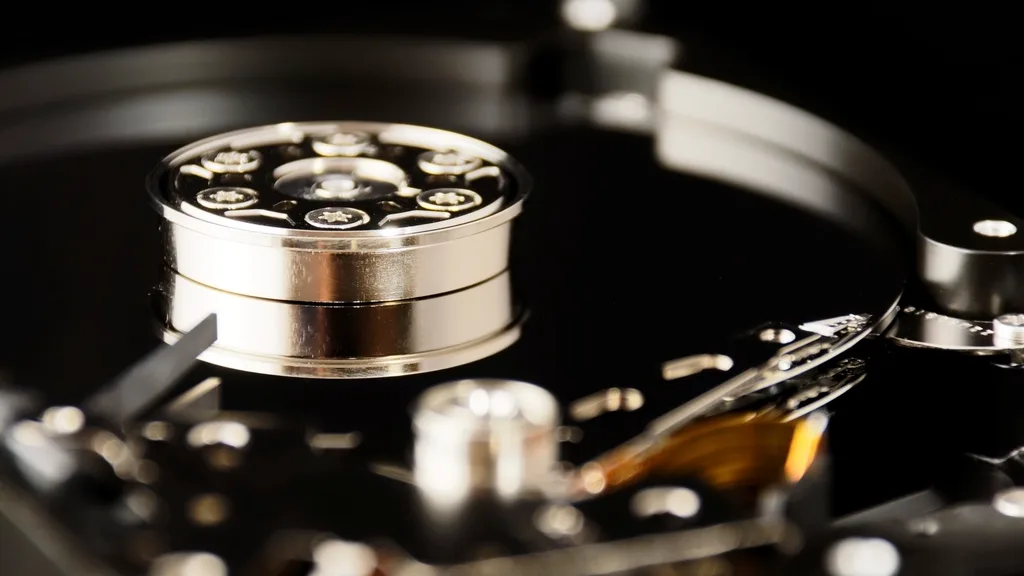 The inside of an open hard disk drive, showing the platter and read arm
