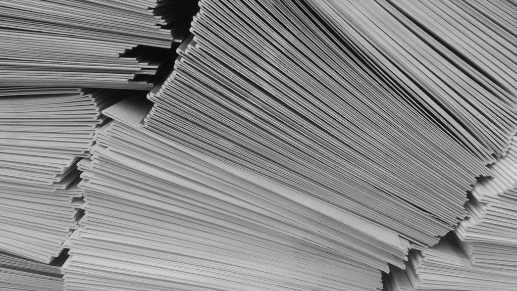 Tall stacks of paper documents, photographed close up in black and white