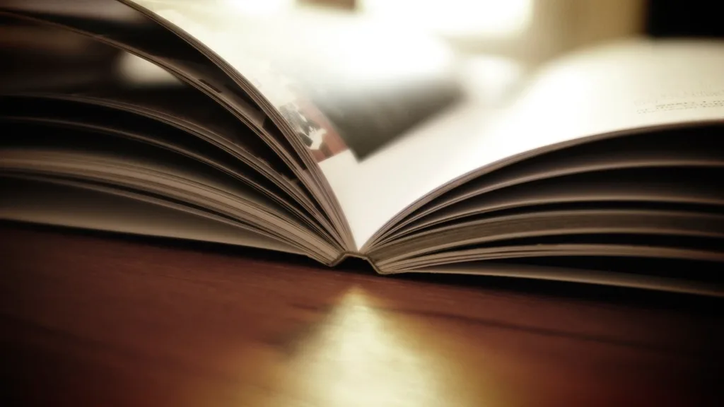 An open book lying on a wooden table in warm light