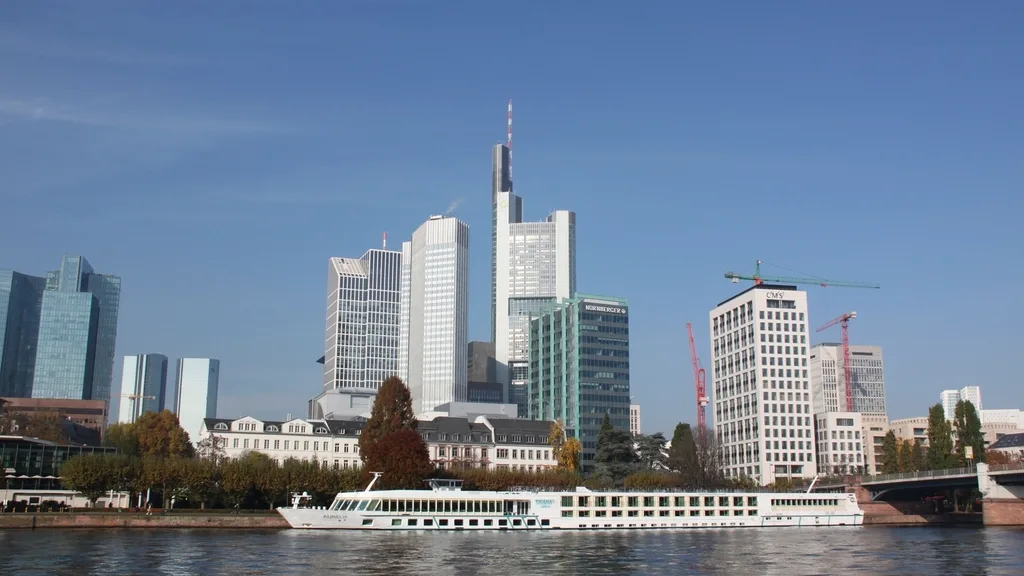 The Frankfurt skyline above the River Main, with a river boat in front